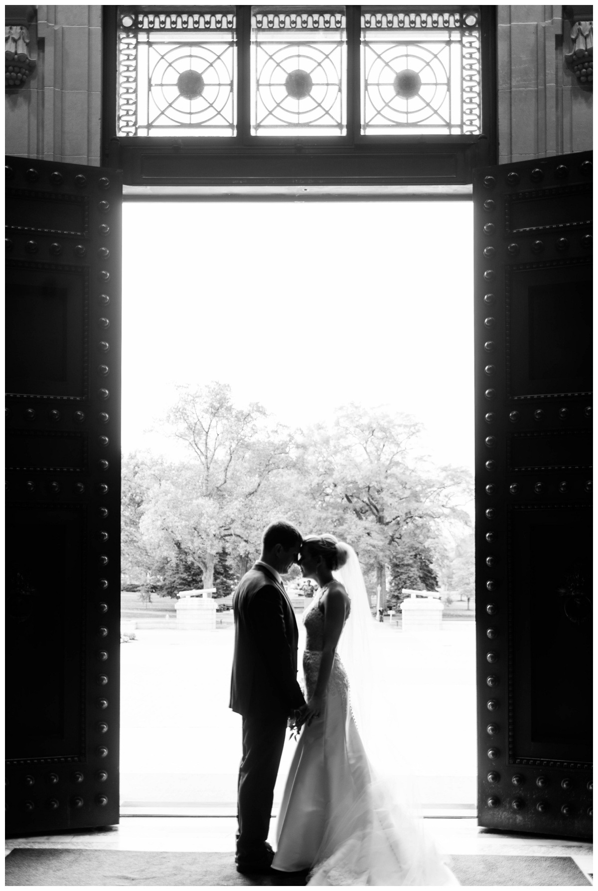 United States Naval Academy chapel wedding veil bride and groom just married photo black and white doors 