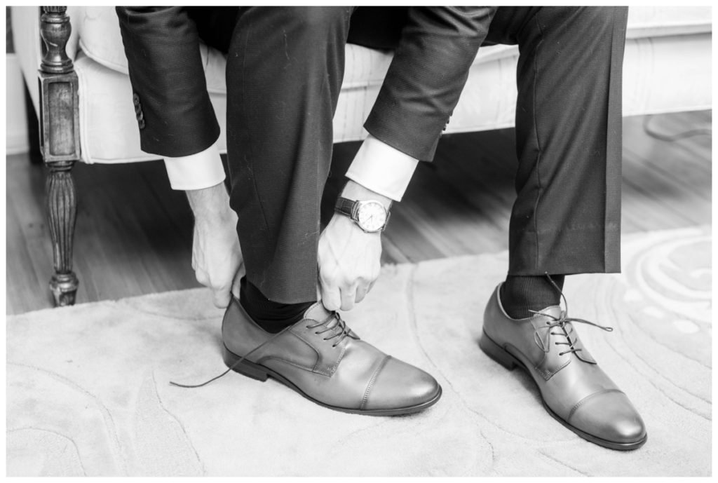 rustic vintage inspired wedding Charlottesville B & B fall Wedding groom putting on shoes closeup
