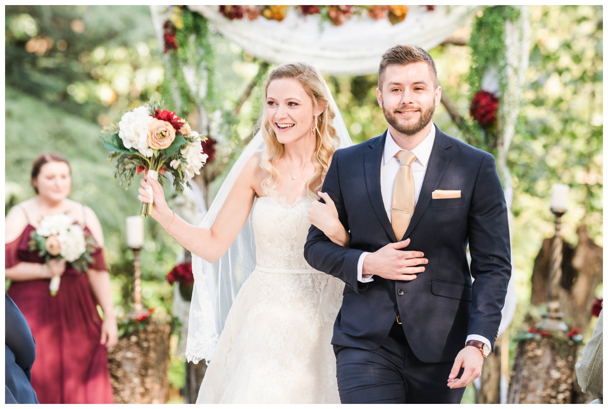outdoor charlottesville virginia wedding fall september groom navy suit officiant bride veil white dress reading vow ceremony wedding venue just married photo just said yes photo bride and groom walking down the aisle