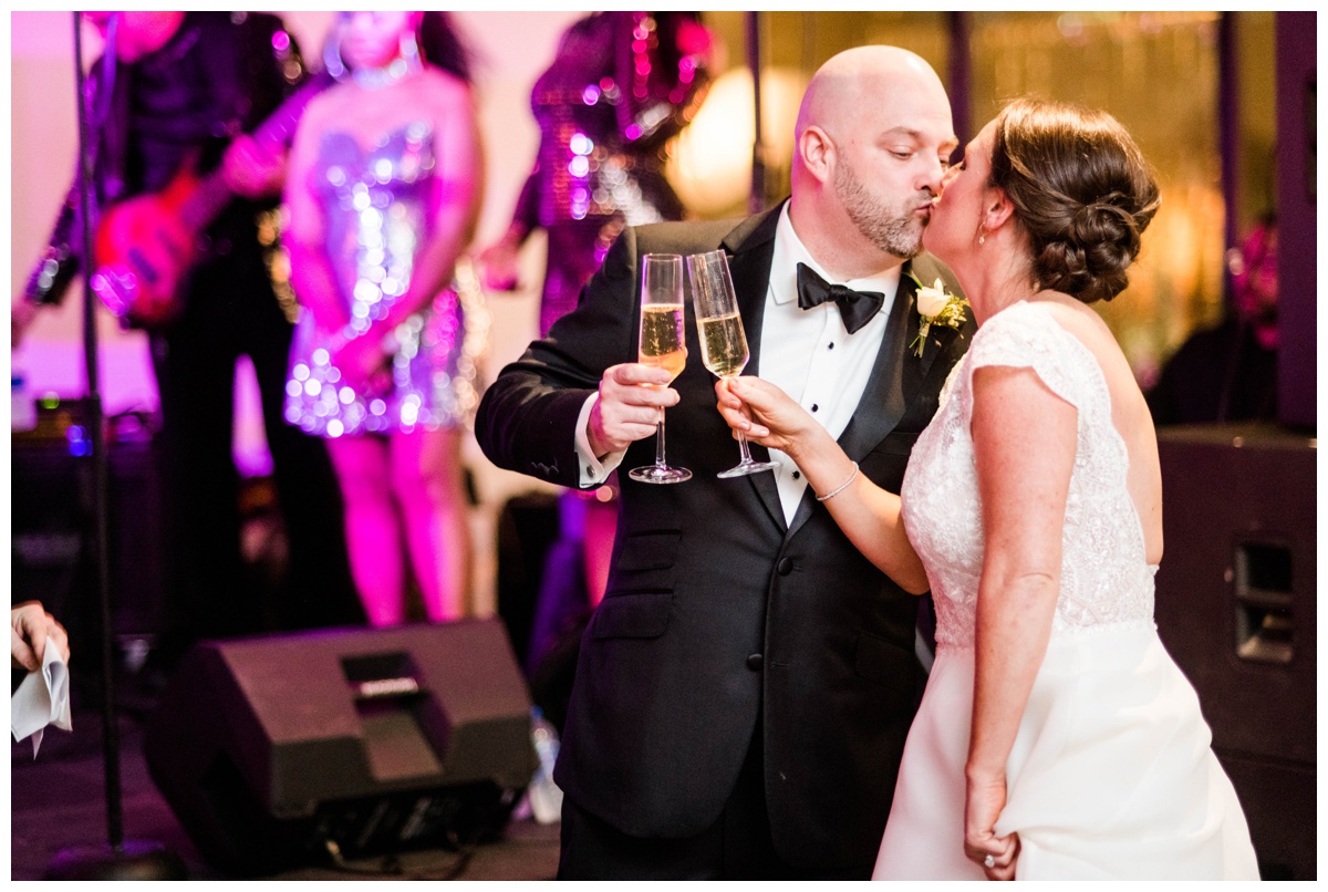 Classic new year's eve wedding black and gold wedding colors richmond virginia wedding venue redskins training center events rva richmond bride and groom wedding photographer raise the glass toast to the bride and groom kissing cheers