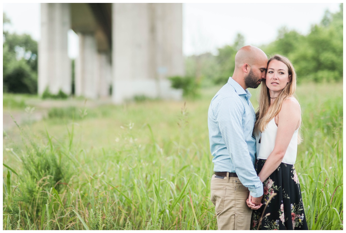 summer belle isle engagement photos in richmond virginia by va wedding photographers sarah & dave photography couple holding hands with overpass backdrop