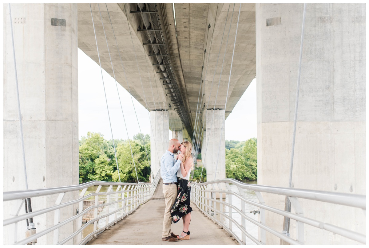 richmond engagement photo inspiration of couple holding onto each other beneath overpass with waterview by richmond va wedding and engagement photographer sarah & dave photography