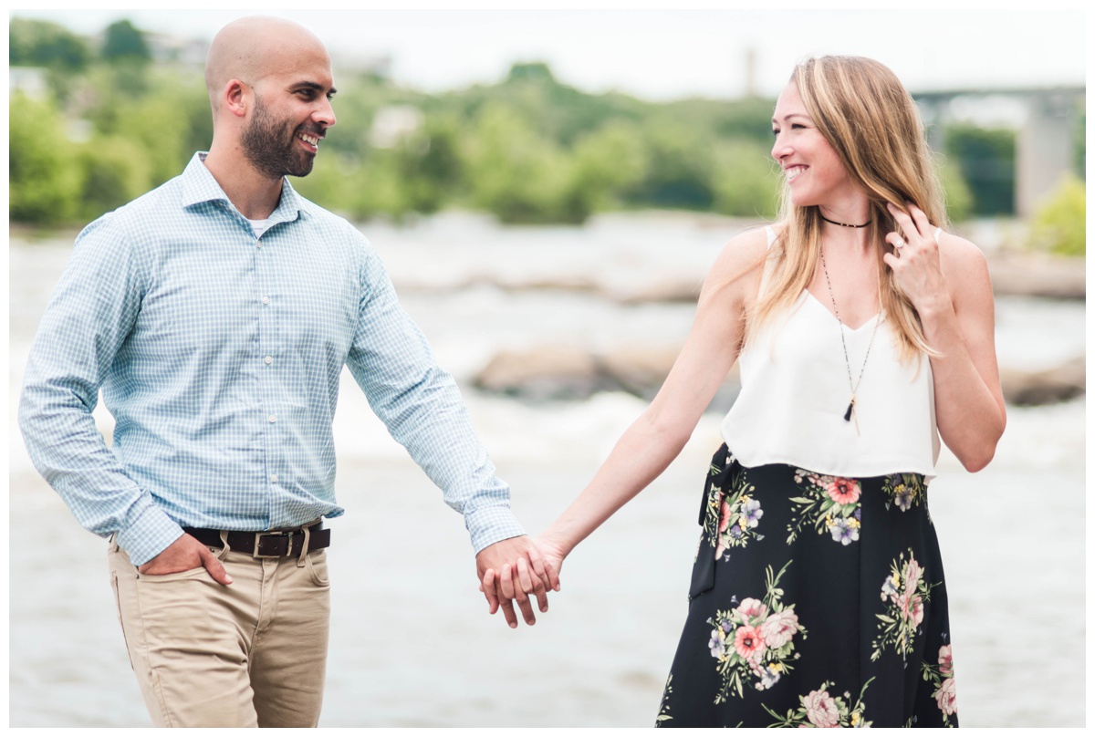 couple holding hands engagement photo inspiration with water view and rocks james creek in richmond virginia by wedding and elopement photographers sarah & dave photography
