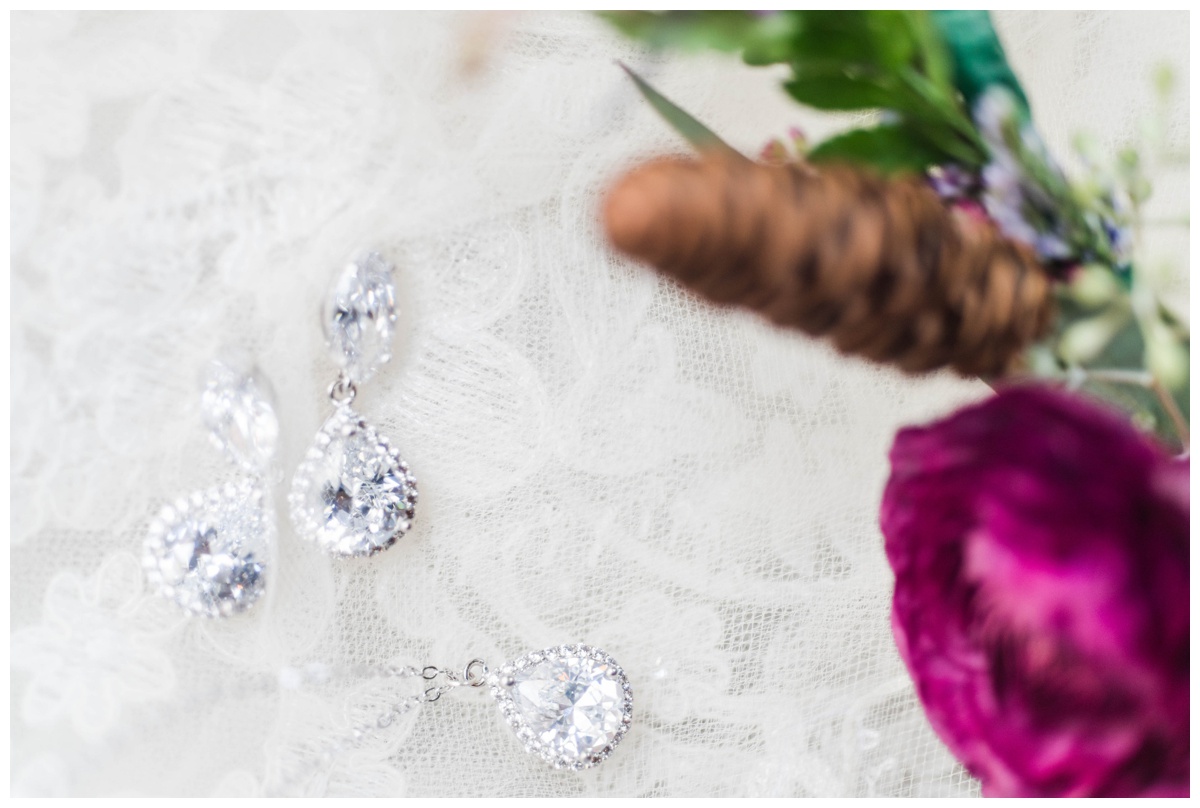 Whimsical Woodland Fall Wedding at mountain memories at thorpewood in thurmont maryland in october by sarah & dave photography richmond wedding photographer bridal jewelry closeup of earrings and necklace with pinecone pinecones on lace wedding dress veil inspiration