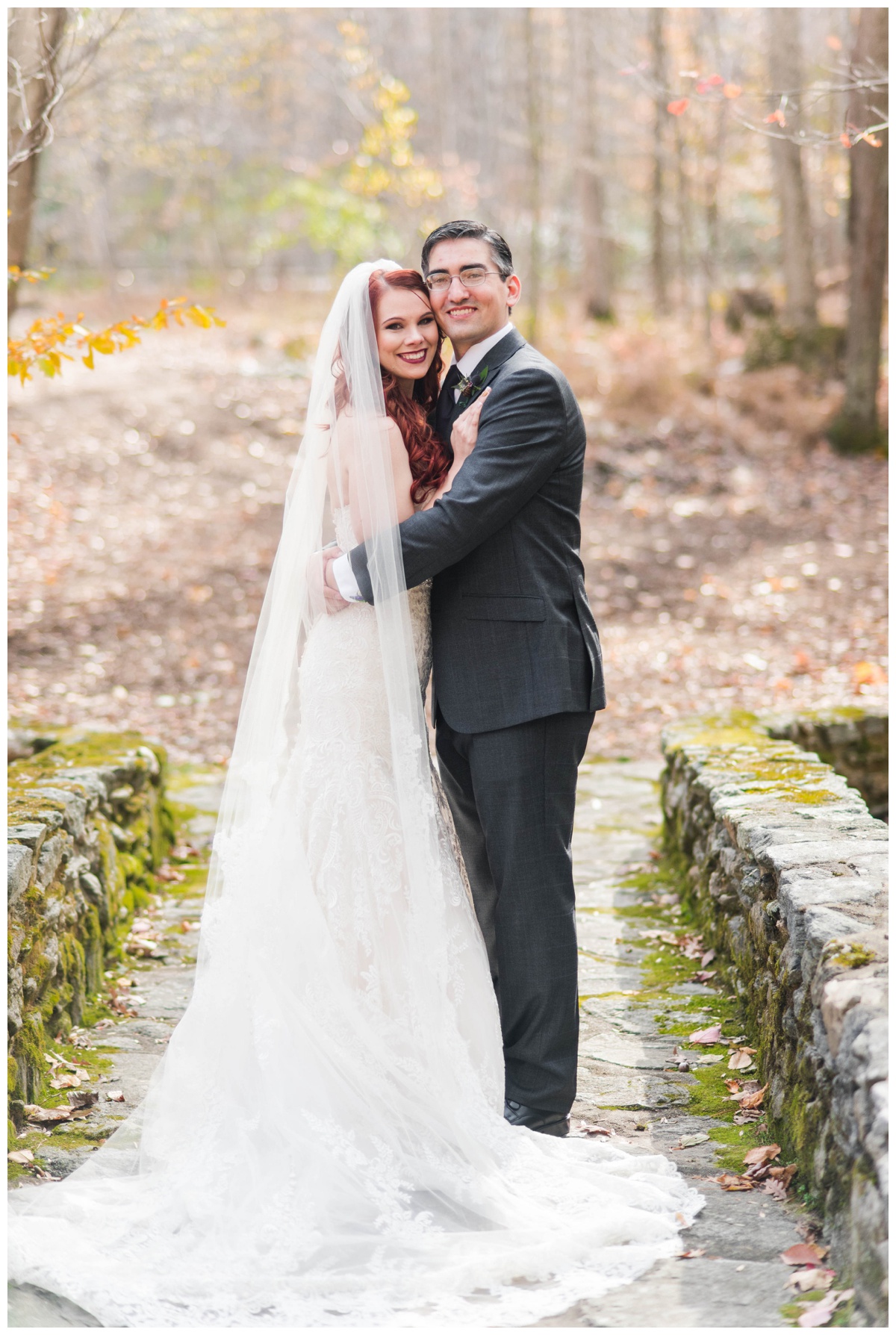 Whimsical Woodland Fall Wedding at mountain memories at thorpewood in thurmont maryland in october by sarah & dave photography richmond wedding photographer groom and bride first look photo inspiration purple tie charcoal gray black suit white wedding dress changing leaves bride and groom close and smiling moss covered stone bride yellow leaves fall wedding inspiration
