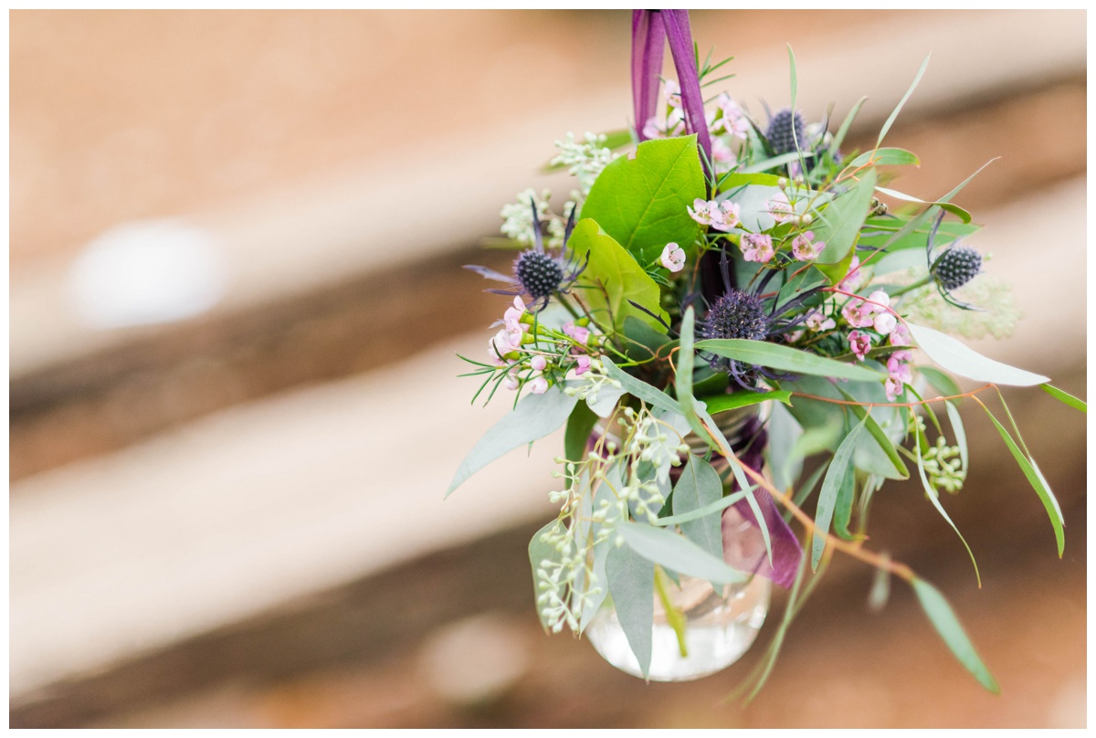 Whimsical Woodland Fall Wedding at mountain memories at thorpewood in thurmont maryland in october by sarah & dave photography richmond wedding photographer woodland enchanted forest inspired flower arrangements in mason glasses budget friendly clear glass vase with purple ribbon thistle wedding flower