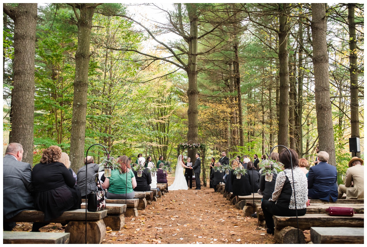 Whimsical Woodland Fall Wedding at mountain memories at thorpewood in thurmont maryland in october by sarah & dave photography richmond wedding photographer forest inspired outdoor ceremony in the woods bride and groom at altar holding hands 