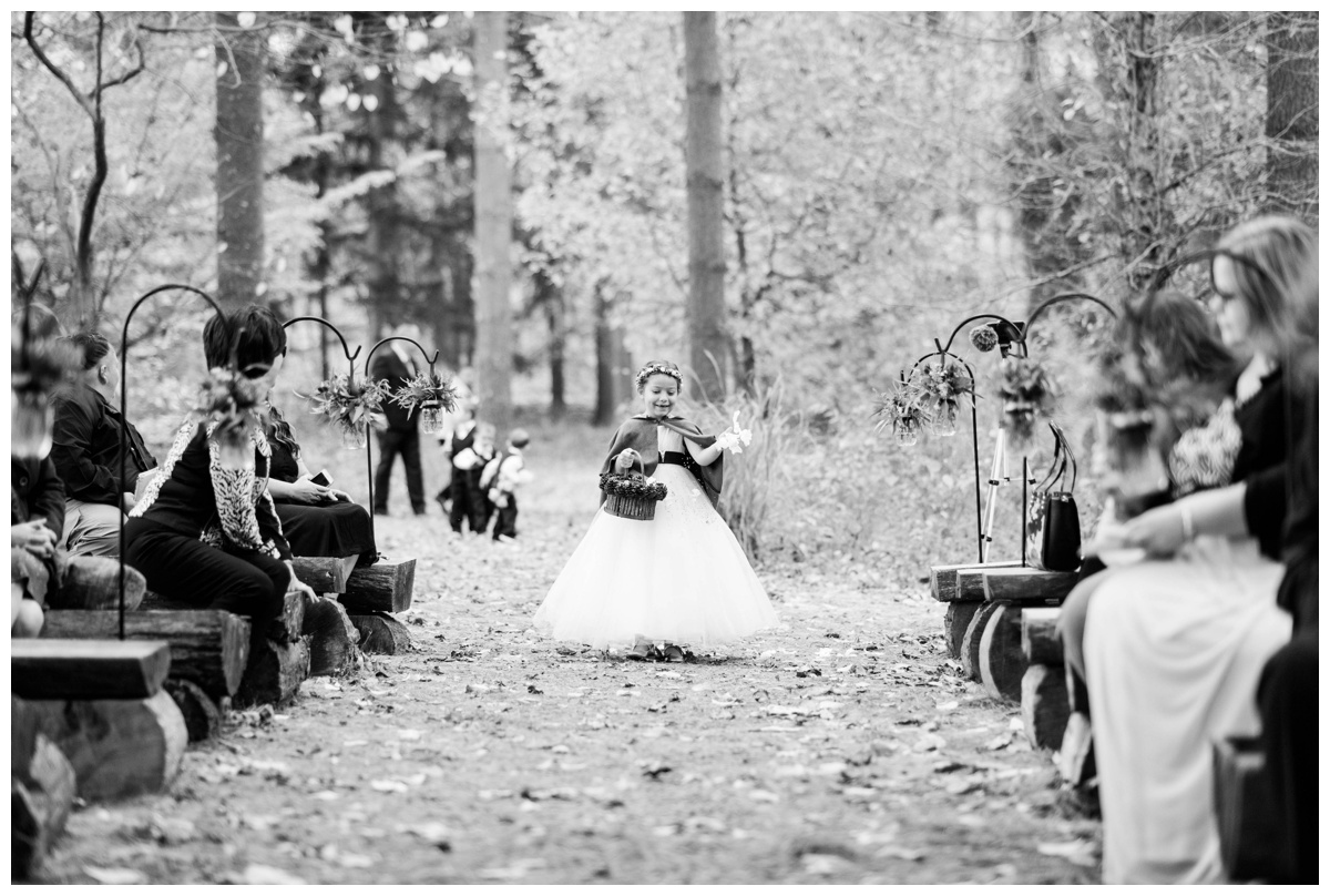 Whimsical Woodland Fall Wedding at mountain memories at thorpewood in thurmont maryland in october by sarah & dave photography richmond wedding photographer forest inspired outdoor ceremony in the woods flower girl carrying moss and pinecone covered basket with green cape and flowercrown