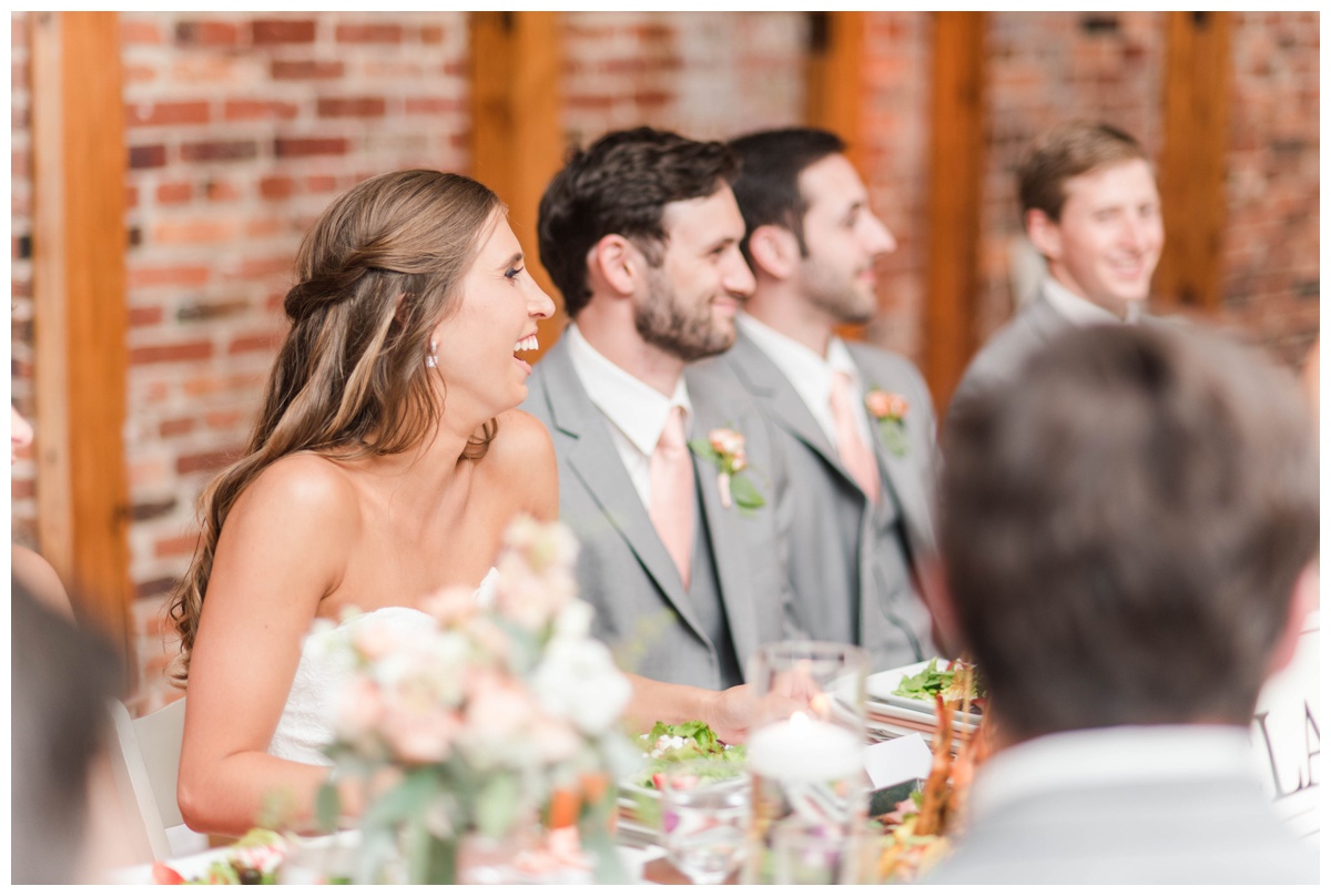 american visionary art museum wedding in baltimore maryland by richmond wedding photographer sarah & dave photography pink coral peach wedding colors summer wedding speeches giving toasts cheers to the bride and groom bride laughing