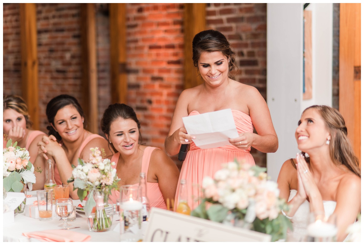american visionary art museum wedding in baltimore maryland by richmond wedding photographer sarah & dave photography pink coral peach wedding colors summer wedding speeches giving toasts cheers to the bride and groom bride laughing