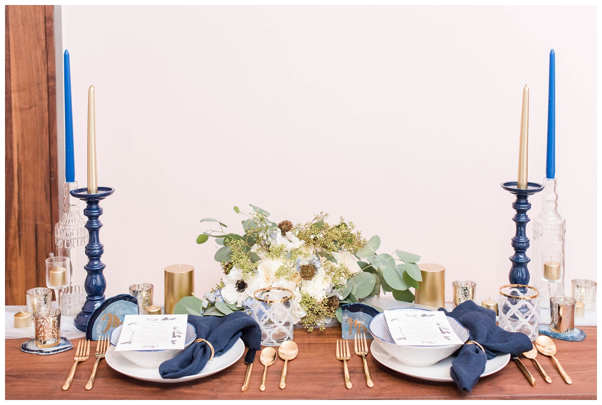 shades of blue wedding inspiration at quirk hotel in richmond virginia by rva wedding photographer sarah & dave photography bride and groom sitting on iconic quirk hotel couch rva virginia wedding blue wedding inspo ideas gold and blue modern wedding reception decor table setting inspo
