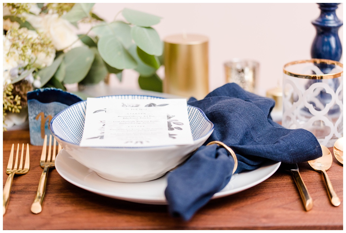 shades of blue wedding inspiration at quirk hotel in richmond virginia by rva wedding photographer sarah & dave photography bride and groom sitting on iconic quirk hotel couch rva virginia wedding blue wedding inspo ideas gold and blue modern wedding reception decor table setting inspo