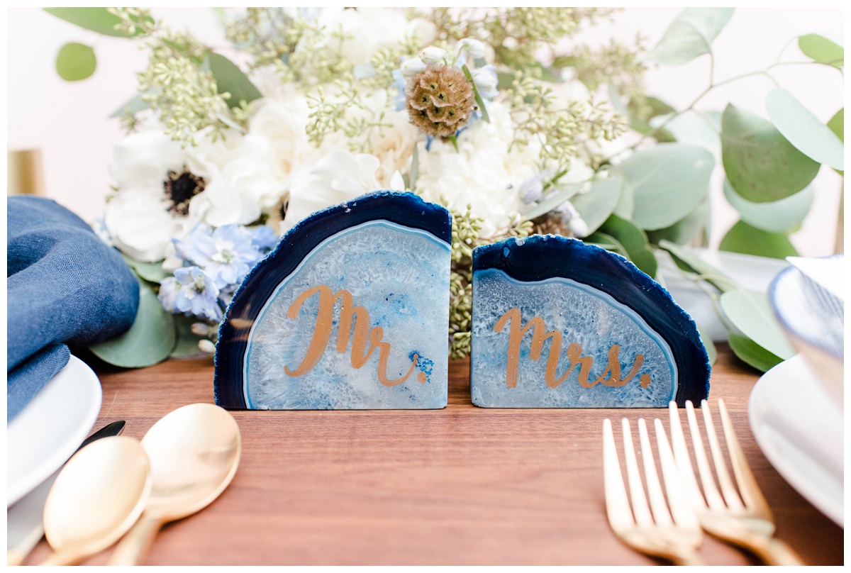 shades of blue wedding inspiration at quirk hotel in richmond virginia by rva wedding photographer sarah & dave photography bride and groom sitting on iconic quirk hotel couch rva virginia wedding blue wedding inspo ideas gold and blue modern wedding reception decor table setting inspo sweetheart table decorations