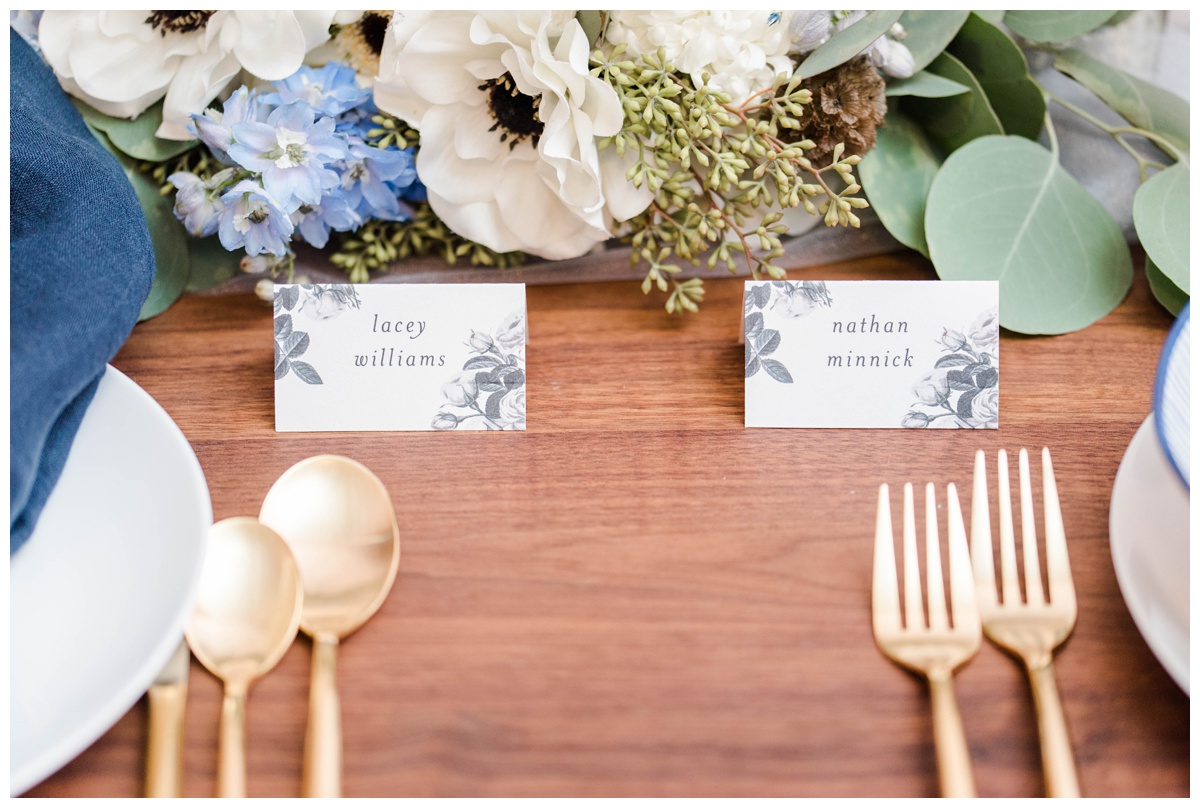 shades of blue wedding inspiration at quirk hotel in richmond virginia by rva wedding photographer sarah & dave photography bride and groom sitting on iconic quirk hotel couch rva virginia wedding blue wedding inspo ideas gold and blue modern wedding reception decor table setting inspo with black and white grayscale name cards inspiration