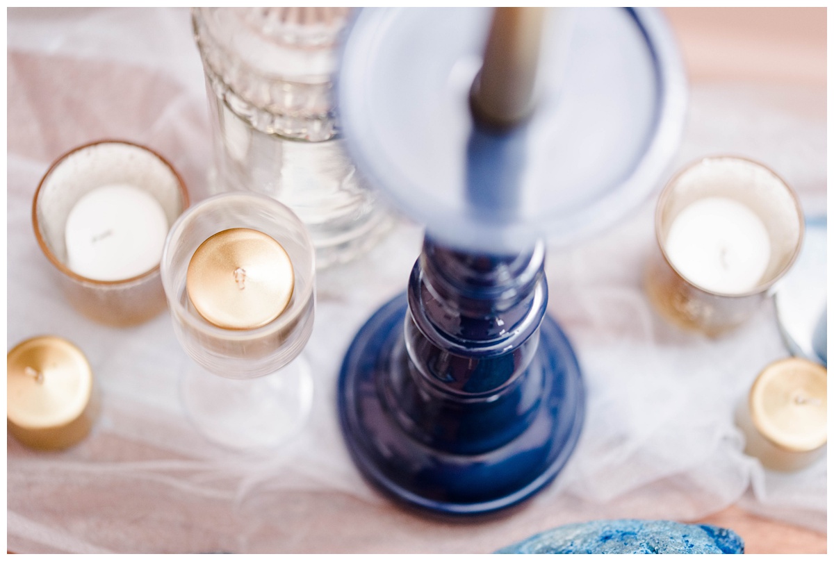 shades of blue wedding inspiration at quirk hotel in richmond virginia by rva wedding photographer sarah & dave photography bride and groom sitting on iconic quirk hotel couch rva virginia wedding blue wedding inspo ideas gold and blue modern wedding reception decor table setting inspo blue candlestick wedding table place setting with candles centerpieces ideas
