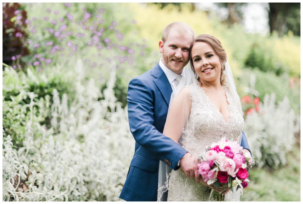 may wedding at oatlands historic house and gardens in the spring pink blue and silver wedding colors bride and groom smiling at each other by sarah and dave photography richmond wedding photographers formal portrait of couple
