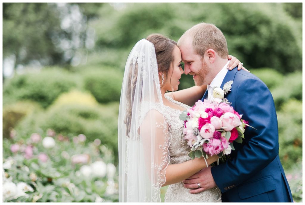 may wedding at oatlands historic house and gardens in the spring pink blue and silver wedding colors bride and groom smiling at each other by sarah and dave photography richmond wedding photographers