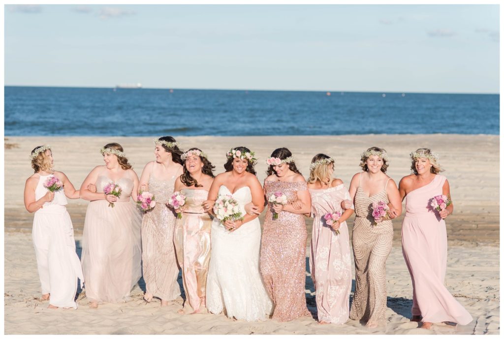 pink and gold mismatched bridesmaid dresses at the beach. photo of wedding party formal portrait photos in the summer.