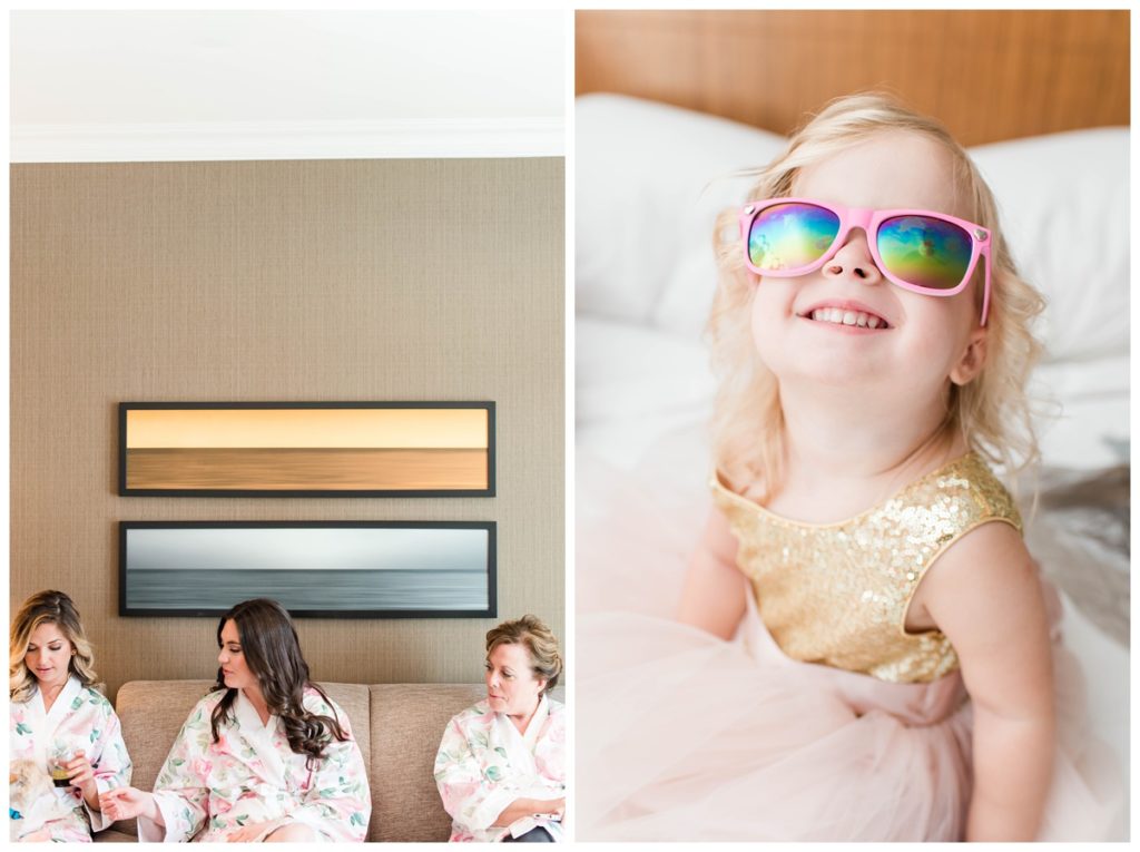 child with pink sunglasses and wedding party in beach theme hotel room with pink bridal robes