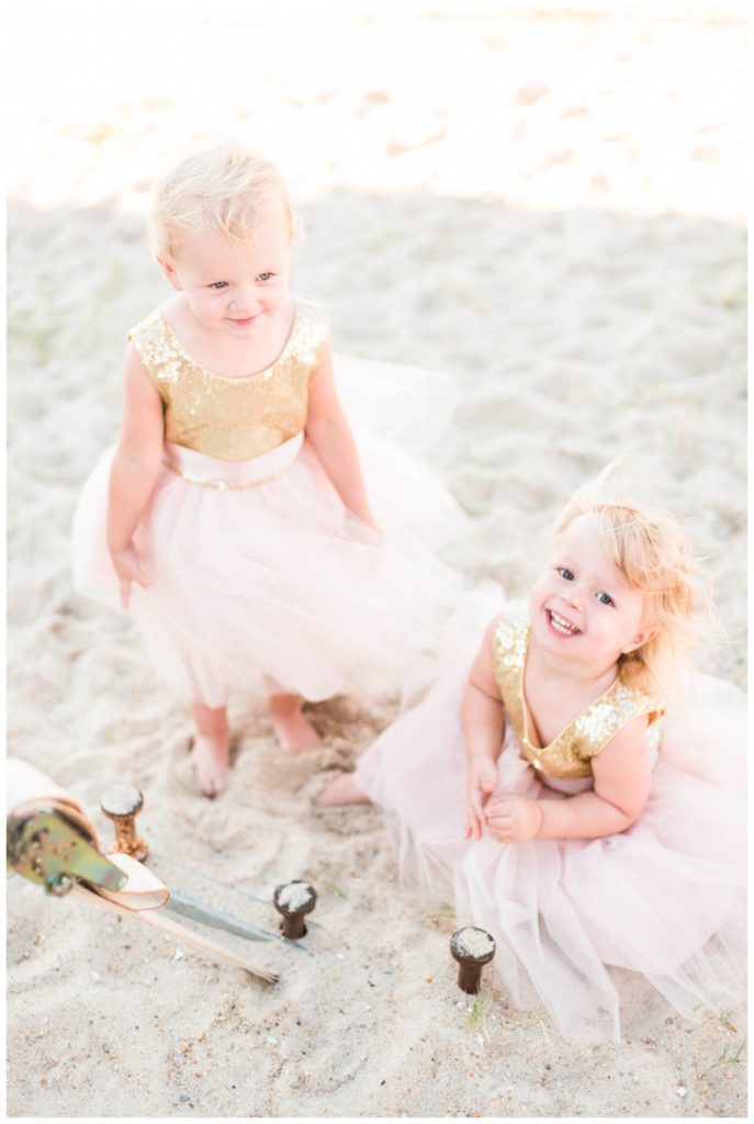 flower girls at beach wedding playing in the sand wearing gold and pink tutu dresses