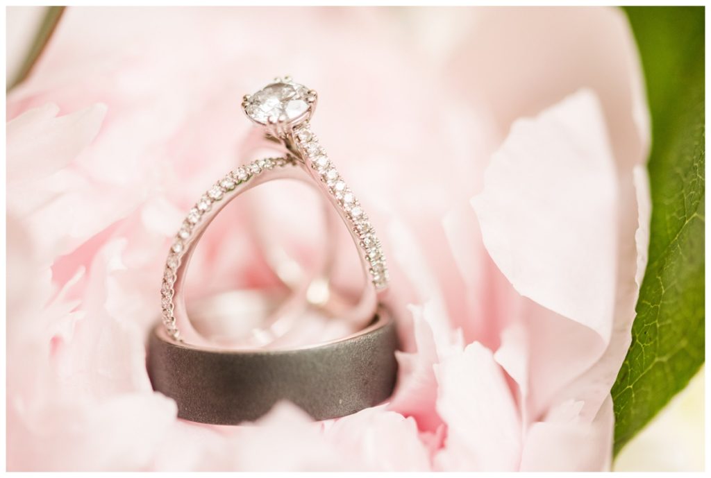 wedding bands and engagement ring stack on pink flowers
