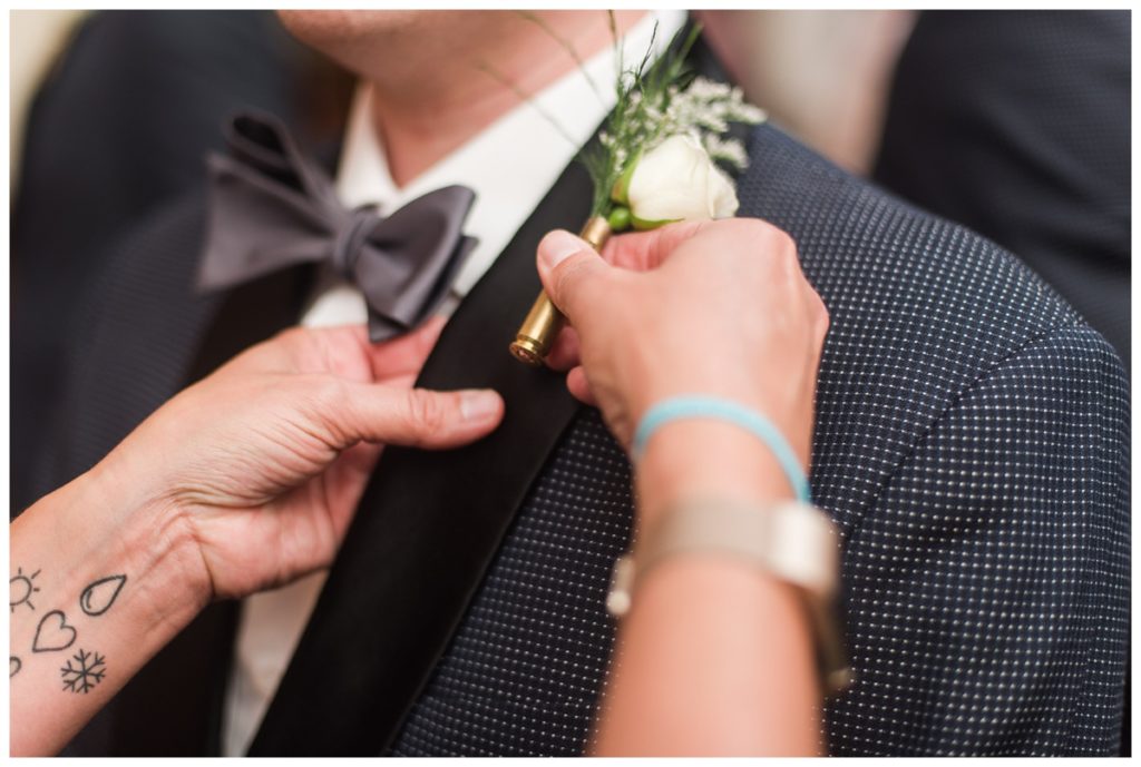 grooms flowers boutonniere with bullet casing in gold greenery and white