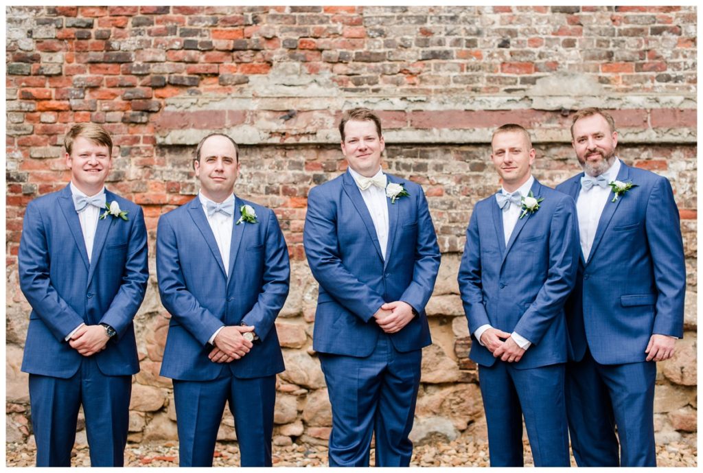wedding party photo at civil war museum and historic tredegar ironworks in richmond rva virginia with our groom, chris, and his groomsmen - all are wearing indigo blue menguin tuxedos and pastel colored striped bowties