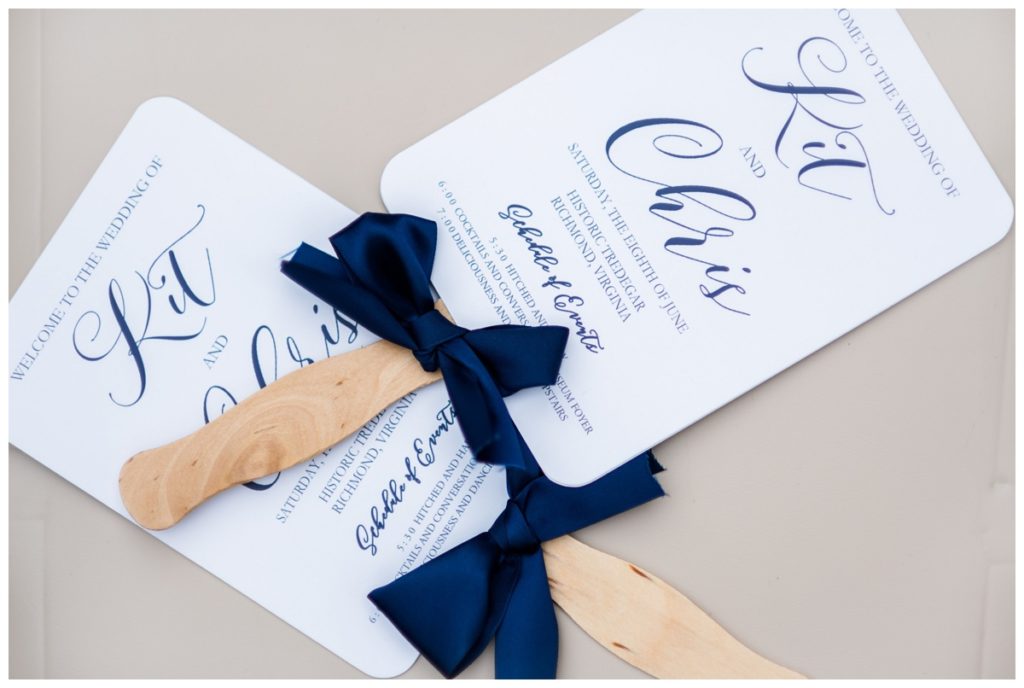 wedding reception decor and details photos -  photo of paper fans of wedding day schedule - list of events - and dark blue navy bows - one of our favorite decoration ideas for wedding ceremony with so much southern charm