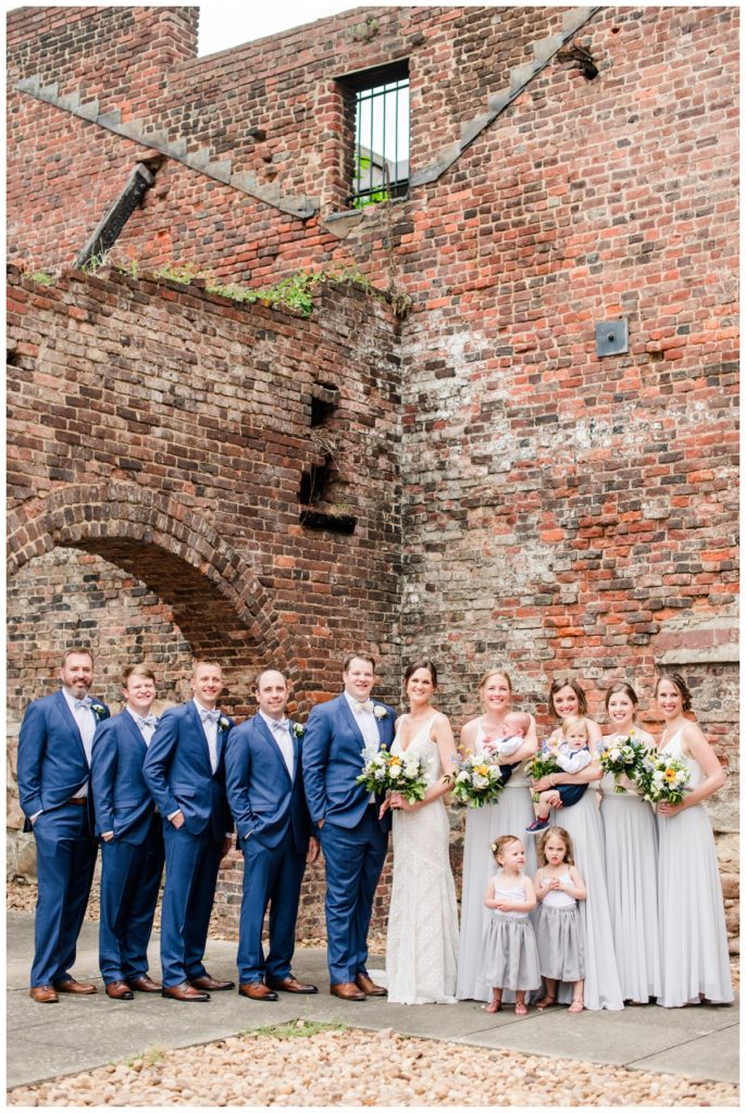 outdoor wedding party photos with indigo blue menguin tuxedos and light grey and white revelry bridesmaid dresses attire at american civil war museum wedding at historic tredegar ironworks in richmond rva virginia by wedding photographer, sarah & dave photography "charming summer wedding with kit and chris in june"