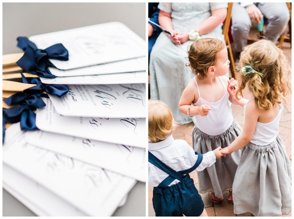 charming summer wedding at the civil war museum and historic tredegar in june - richmond virginia rva wedding photographer, sarah & dave photography - photo of ceremony decor - wedding program + paper fan with wooden stick and cute dark blue ribbon bows and flower girls wearing flowy light grey skirts and white tops and ringbearer wearing indigo dark blue romper shorts outfit with suspenders and button up white shirt - so adorable!!!