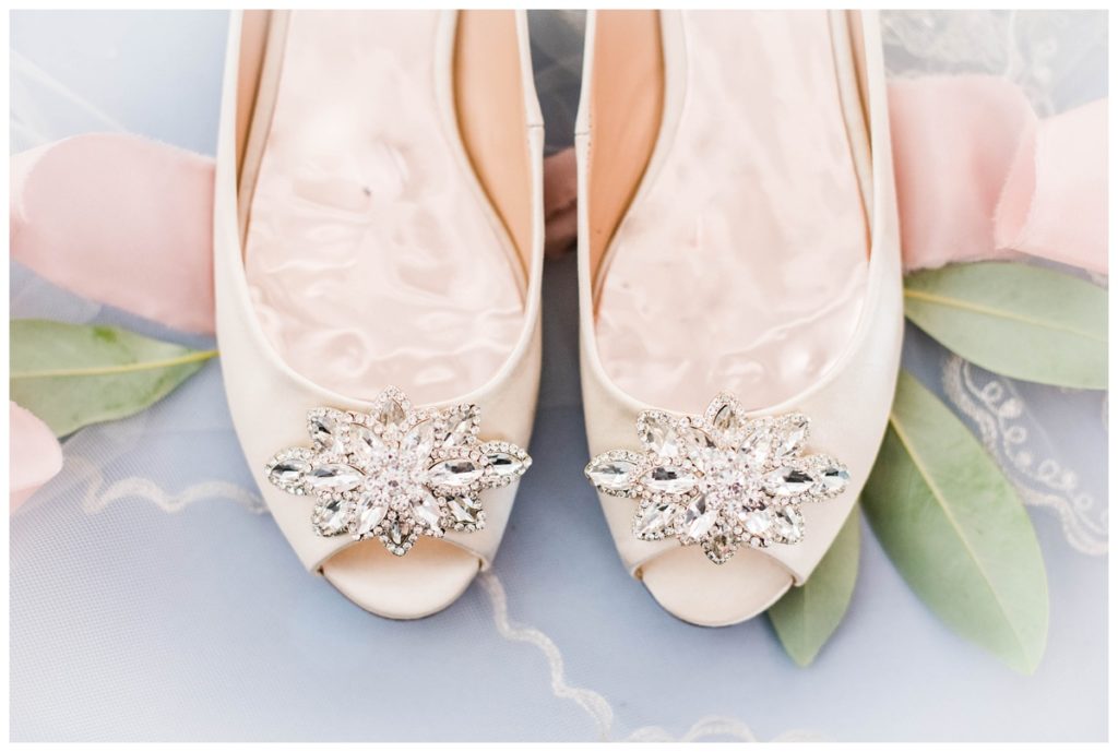 ivory satin badgley mischka wedding shoes with kitten heels and peep toe and jewels flatlay - bridal details photo at summer wedding venue in rva
