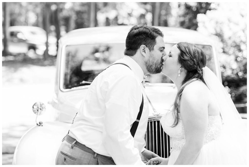 black and white wedding photo - bride and groom kissing - wedding portrait outdoors - rolls royce - fairytale wedding inspiration at the boathouse at sunday park in richmond rva by wedding photographer sarah & dave photography - june wedding - summer wedding - cute wedding portrait
