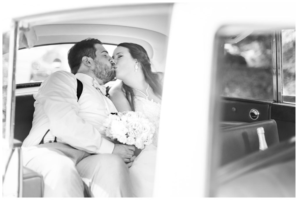 couple kissing in rolls royce formal exit at the boathouse weddings reception in richmond va by rva wedding photographer, sarah & dave photography