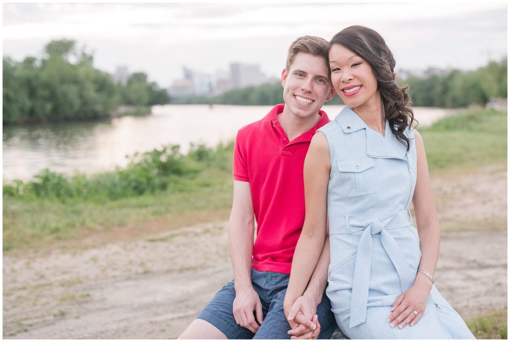 Couple sitting in front of the James River at Rocketts Landing Engagement Photo Session